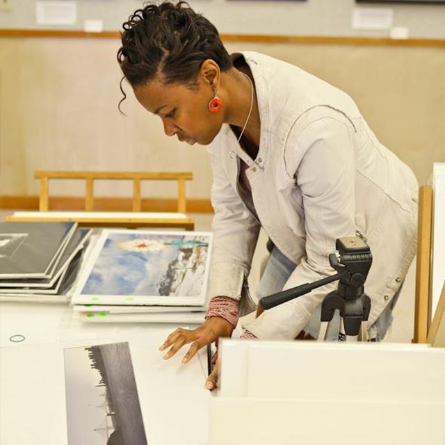 Woman looking through stack of photography