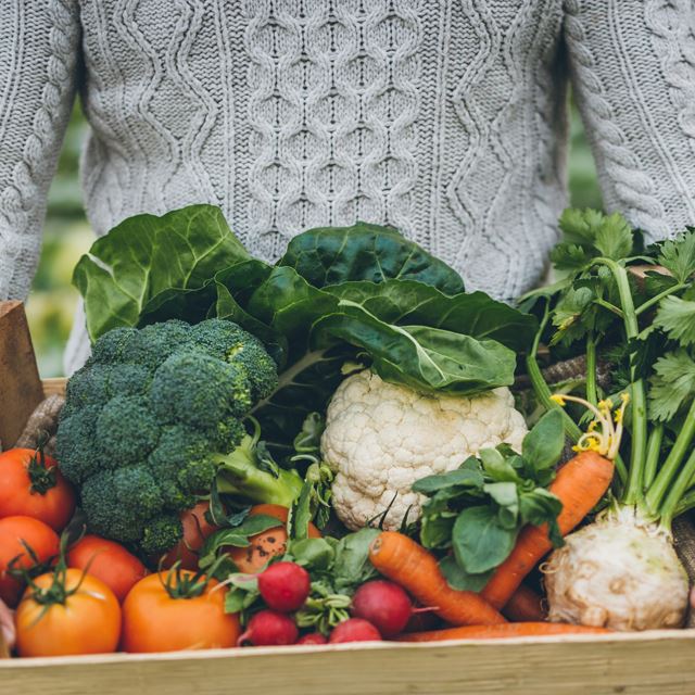 Person holding box of fresh produce