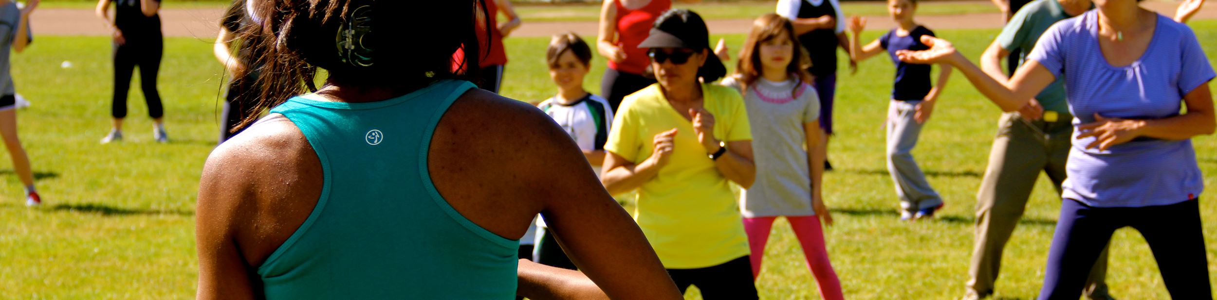 Kids and adults doing zumba in a park