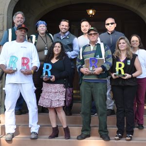 Parks and Recreation employees holding "R" trophies