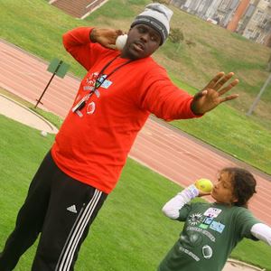 Parks and Recreation employee demonstrating shot put to little girl