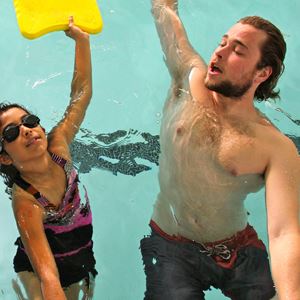 Instructor teaching little girl to swim