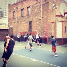 Men playing basketball at Willie "Woo Woo" Wong Playground