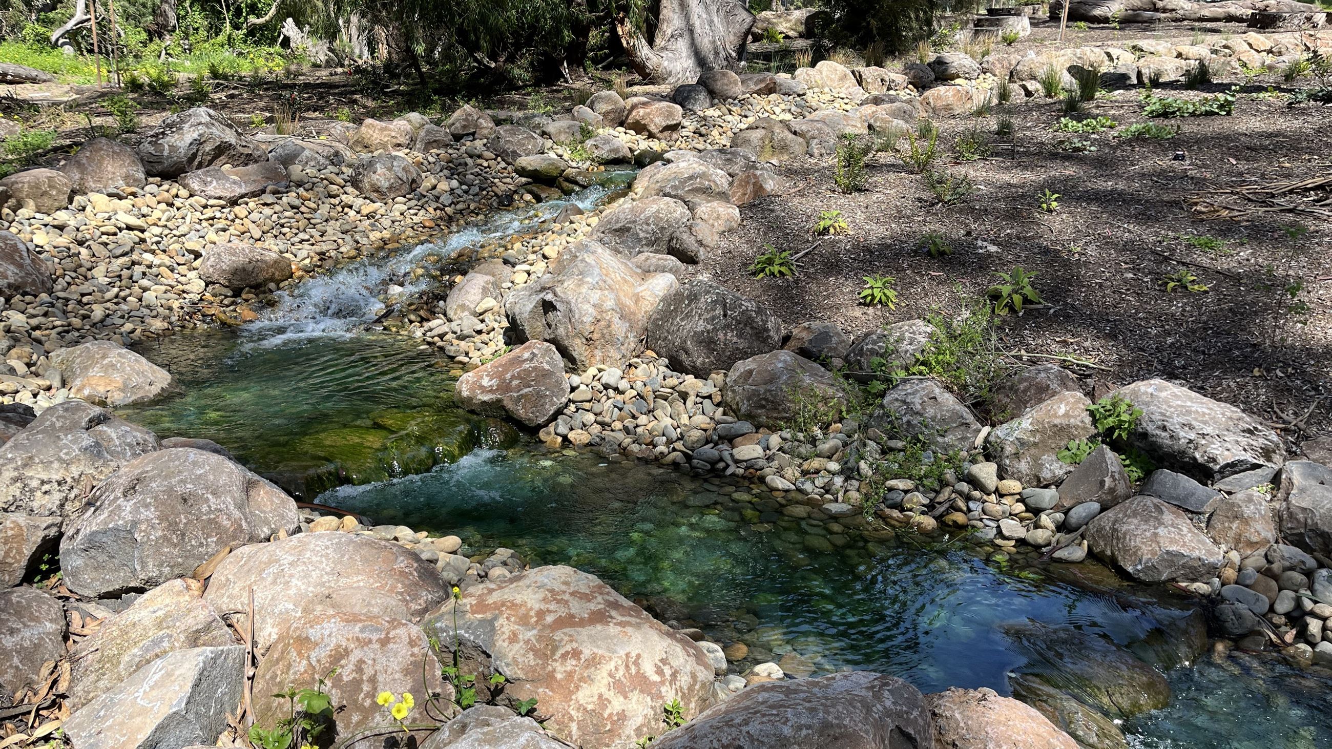 Water flows over the rocks of the new cascade feature